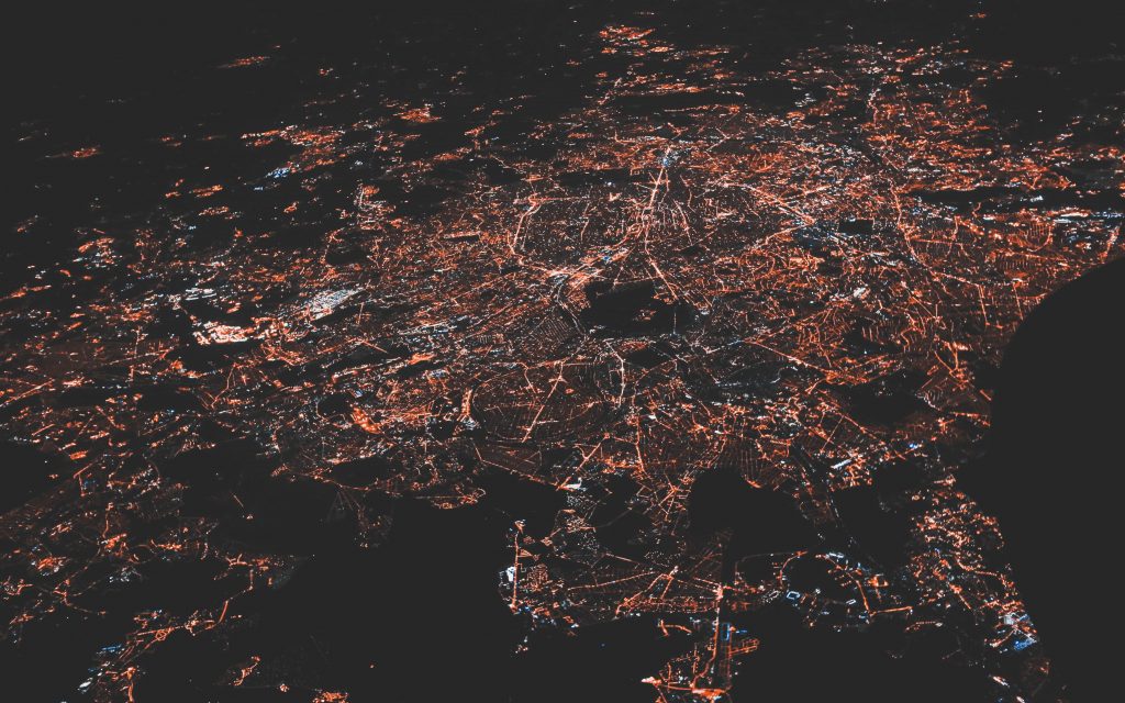 Airplane height view of lit up cities and towns at night