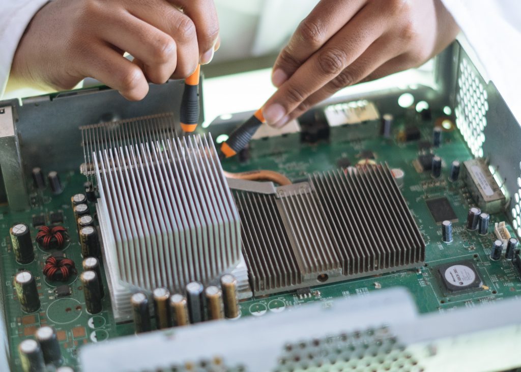 Closeup of technician testing an electronic circuit board